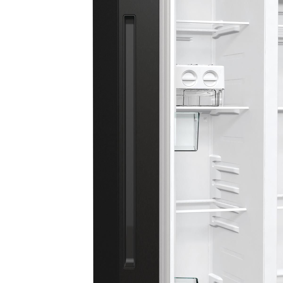 Ein offener Kühlschrank. Schwarze Tür links mit Griff, weißer Innenraum mit Regalen und Eisbereiter.