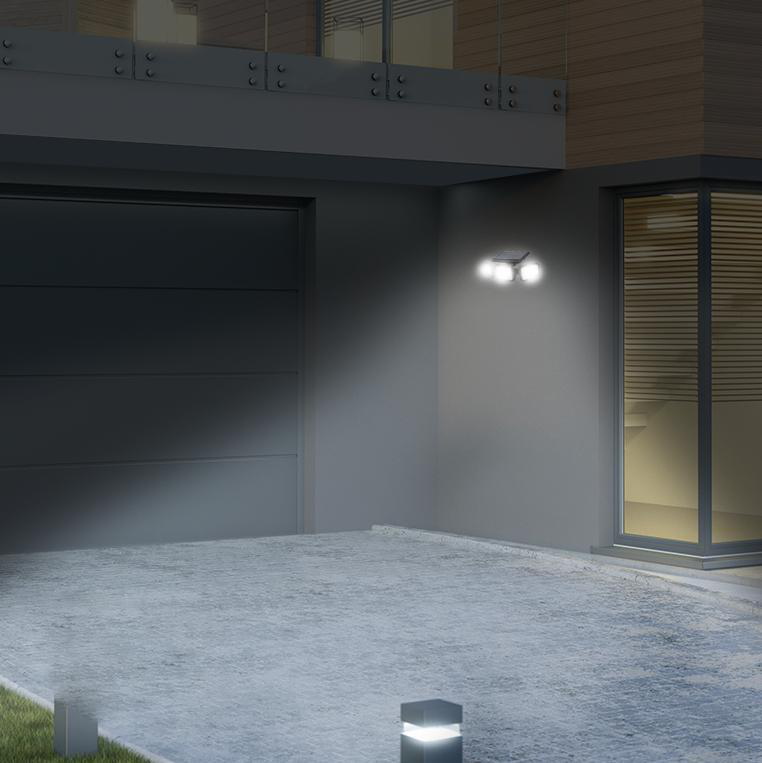 Außenansicht einer Garage und Einfahrt. Ein Licht beleuchtet die Szene.
