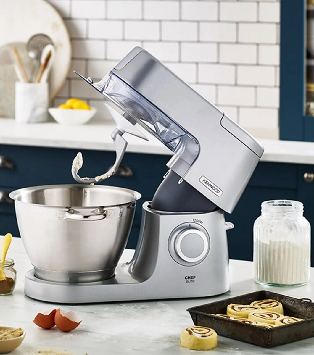 Srebrny mikser. Miska jest na miejscu. Składniki i jedzenie są na blacie.