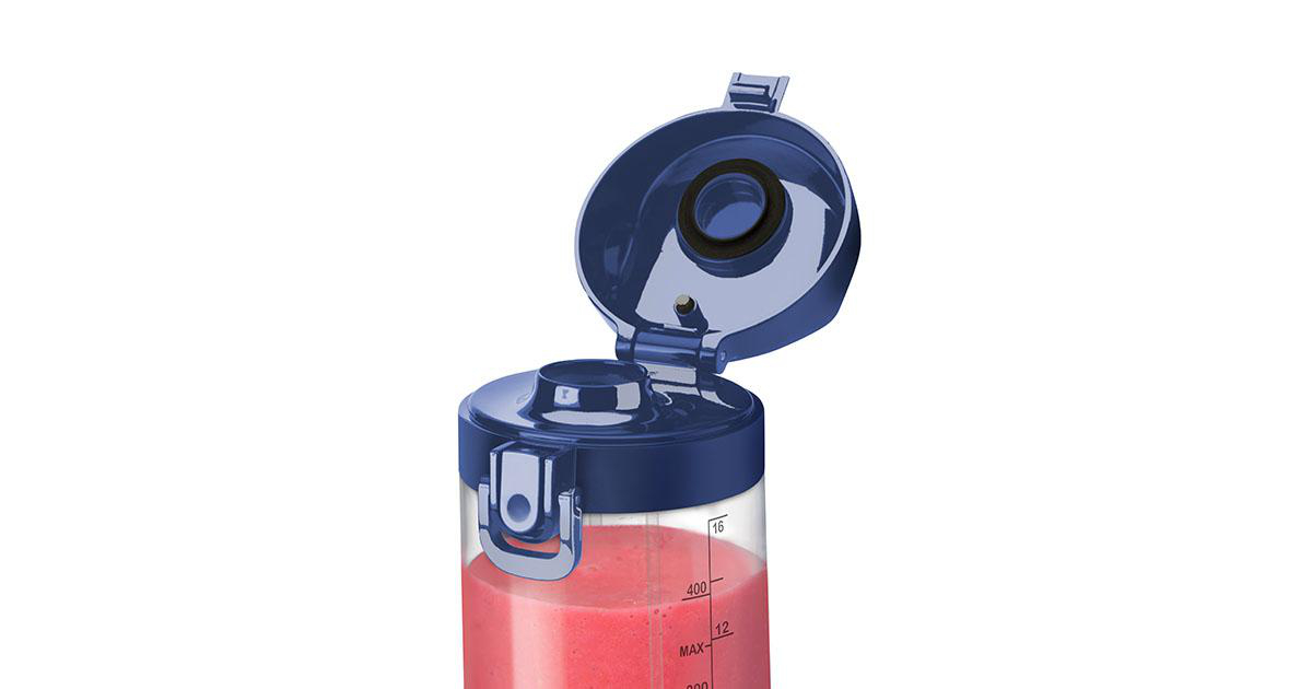 Nahaufnahme eines blauen Mixers mit pinkfarbenem Smoothie, Deckel offen.