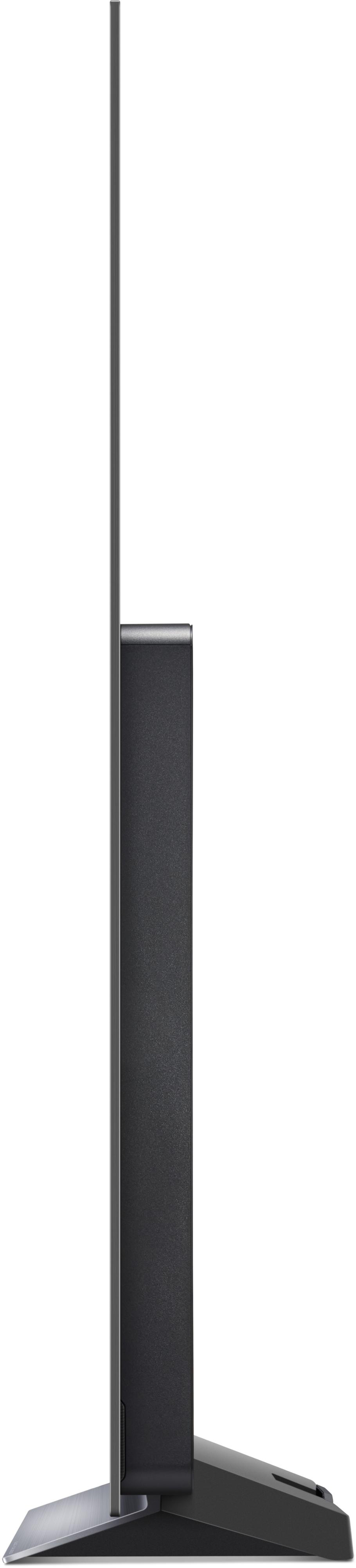 Seitenansicht eines schwarzen, schlanken Fernsehers auf einem Ständer, vor weißem Hintergrund.