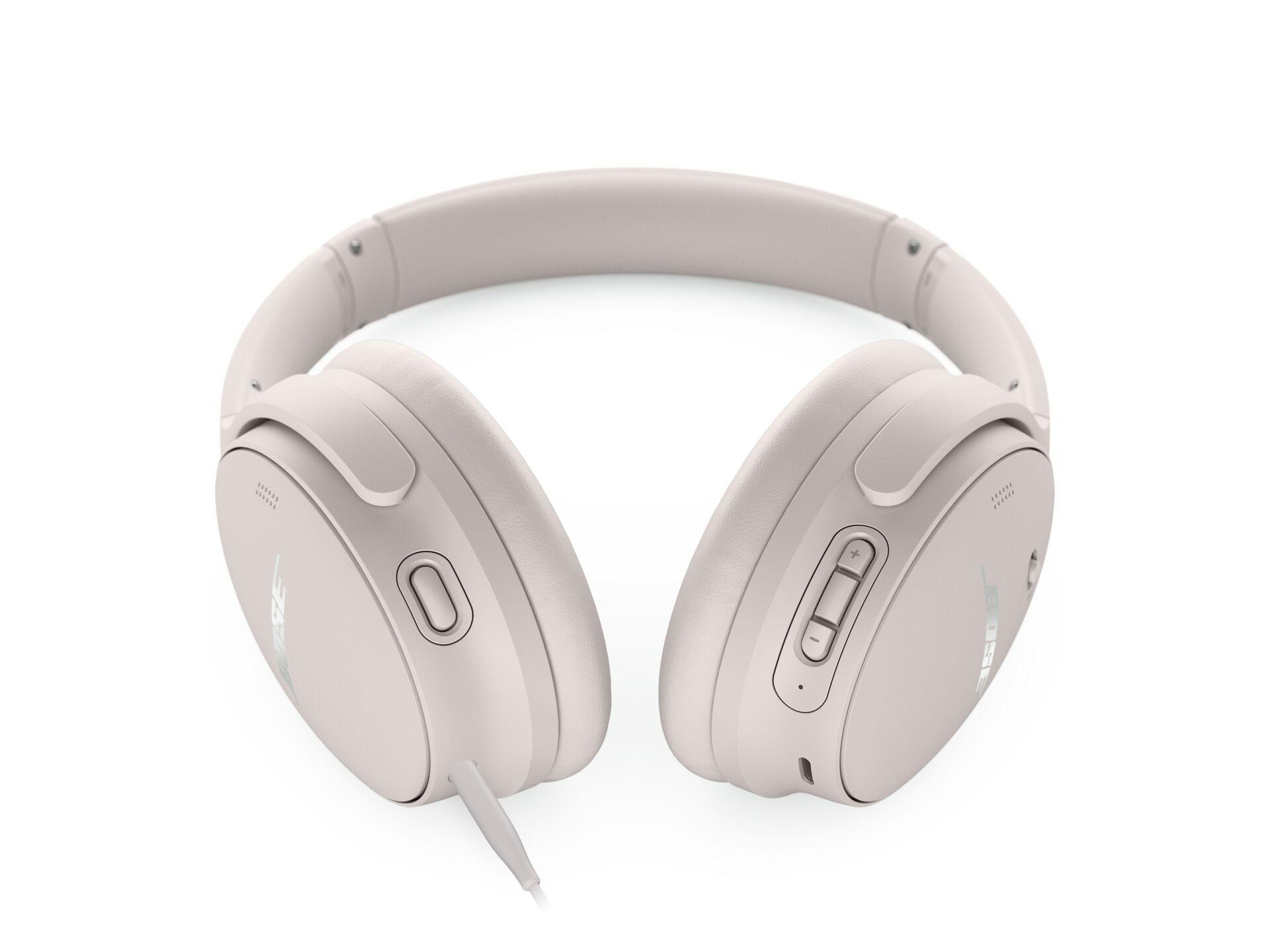 Hellrosa Kopfhörer, schräge Ansicht, auf weißem Hintergrund.