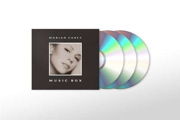 Pochette de l'album 'Music Box' de Mariah Carey et trois CD sur fond blanc.