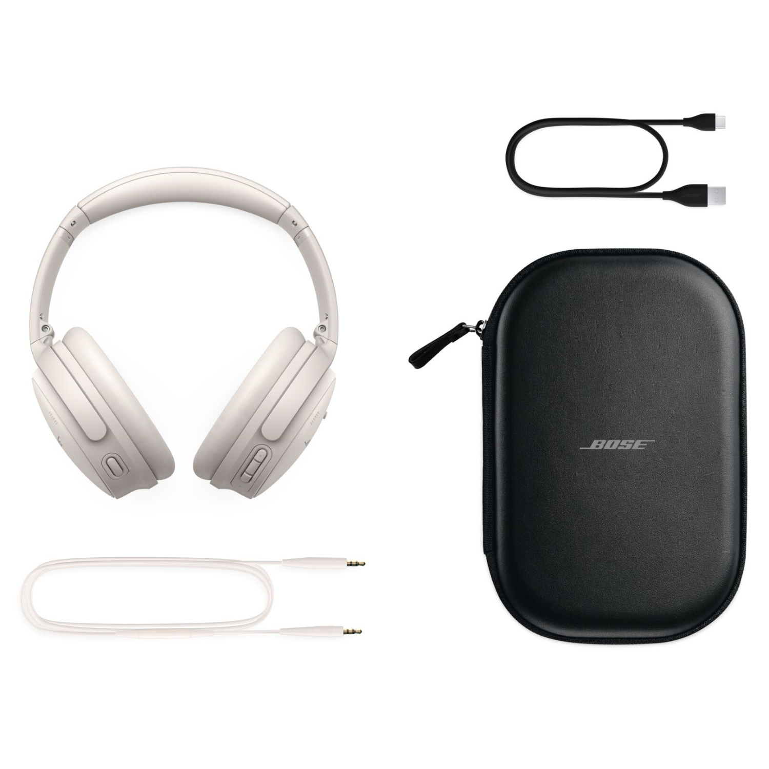 White headphones, a black case, and two charging cables are on a white surface.