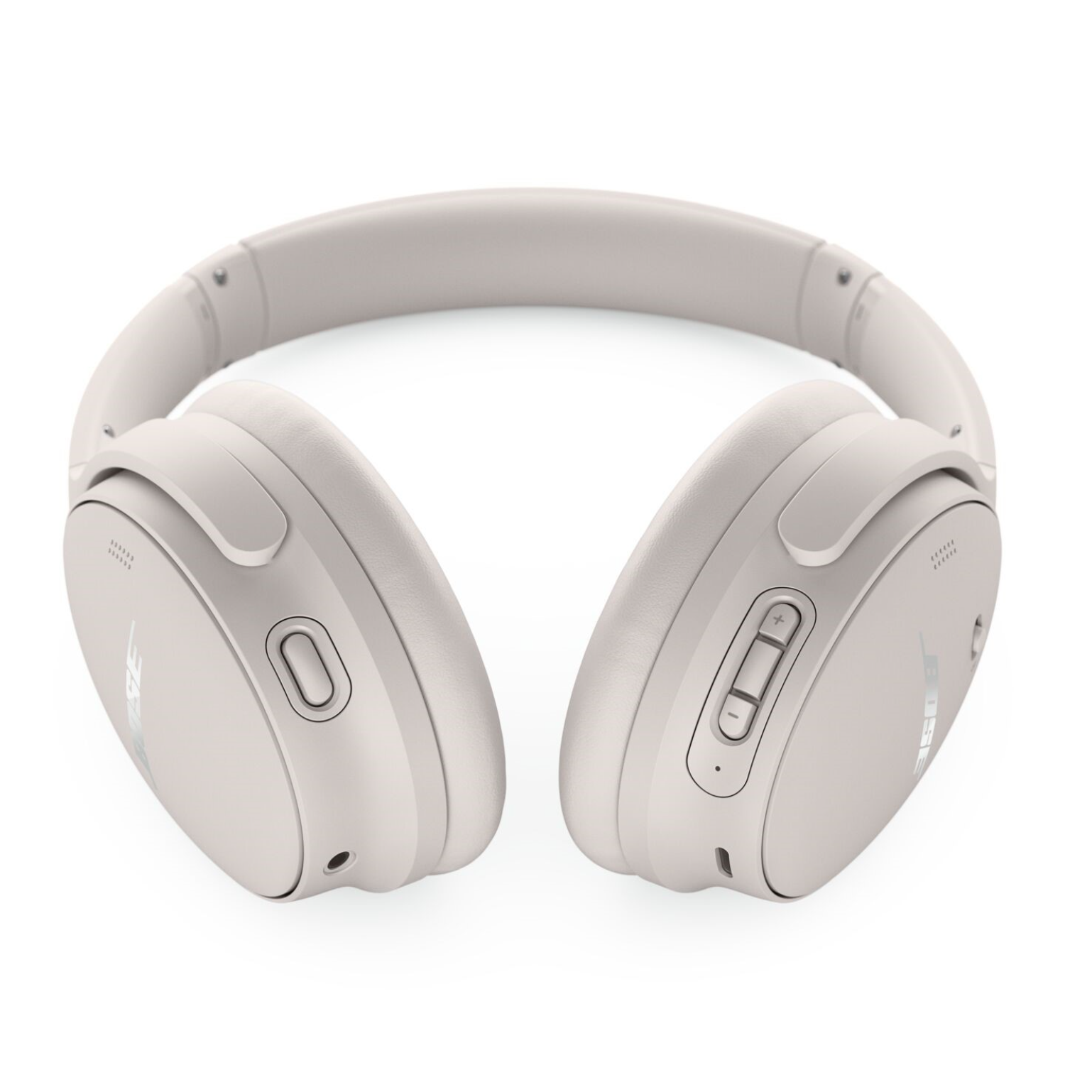 Headphones in light grey color, lying on a white surface. The Bose logo is visible on each earcup.