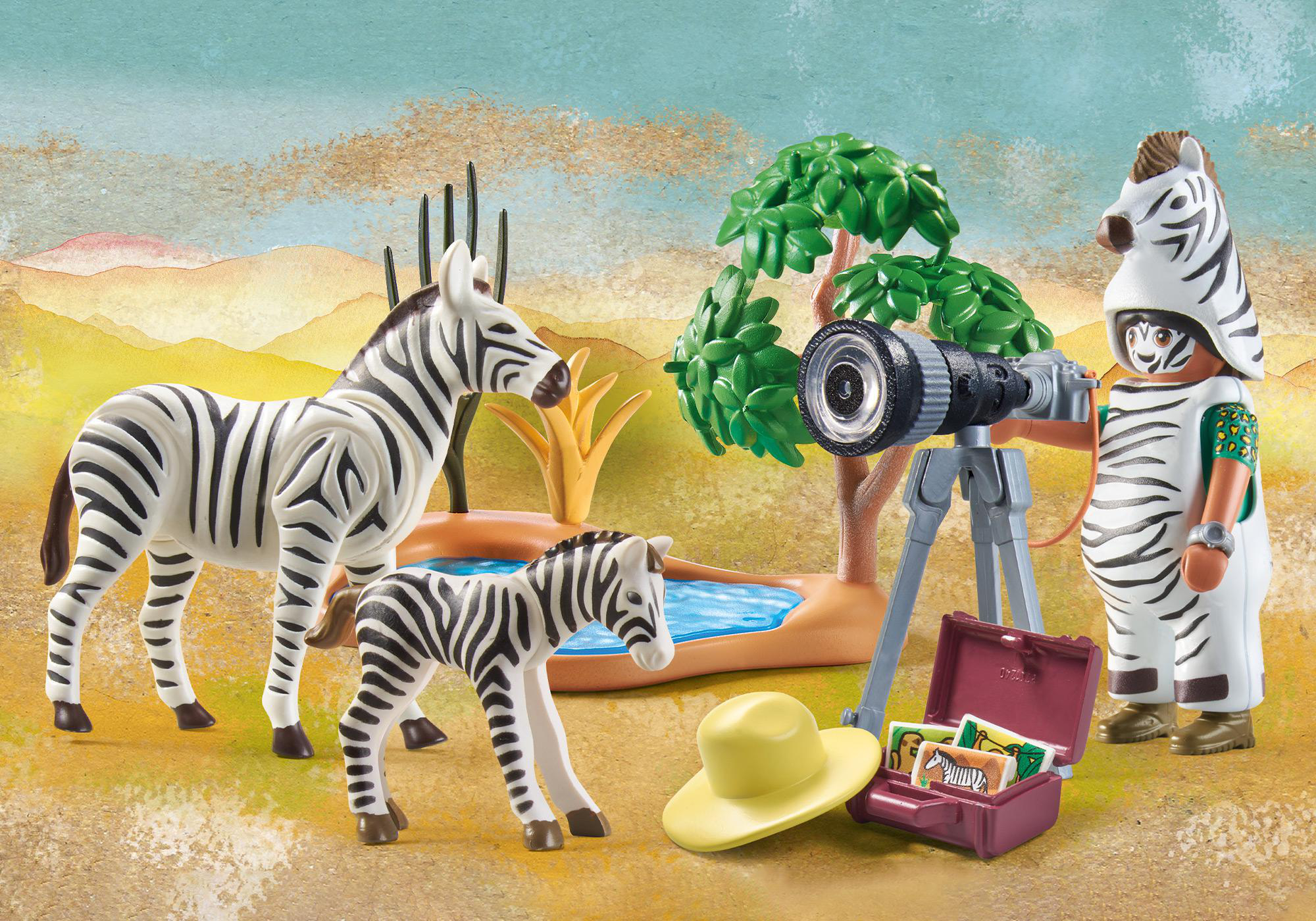 Eine Playmobil-Zoo-Szene mit Zebras, einem Fotografen im Zebrakostüm und einem kleinen Pool.