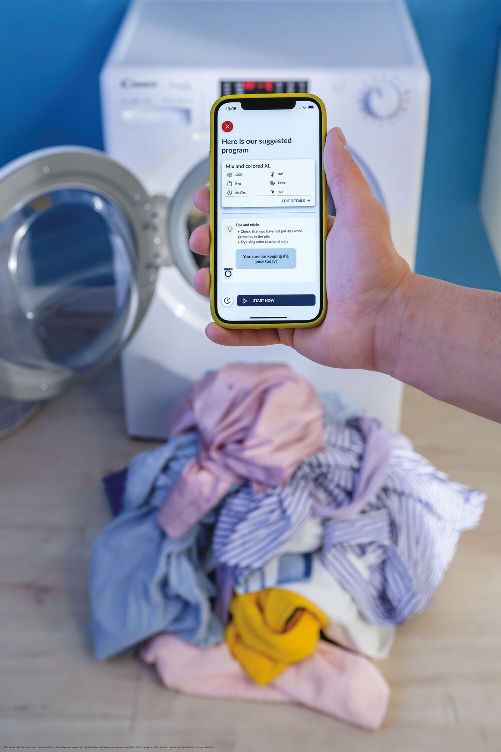 Una persona sosteniendo un teléfono que muestra una interfaz de lavadora, con ropa delante.