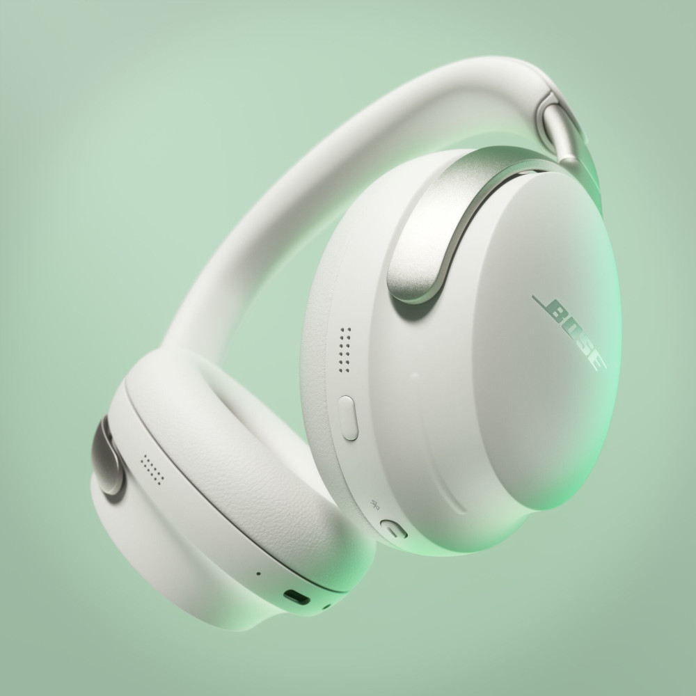 Witte Bose-hoofdtelefoon met zilveren accenten, zwevend op een groene achtergrond.