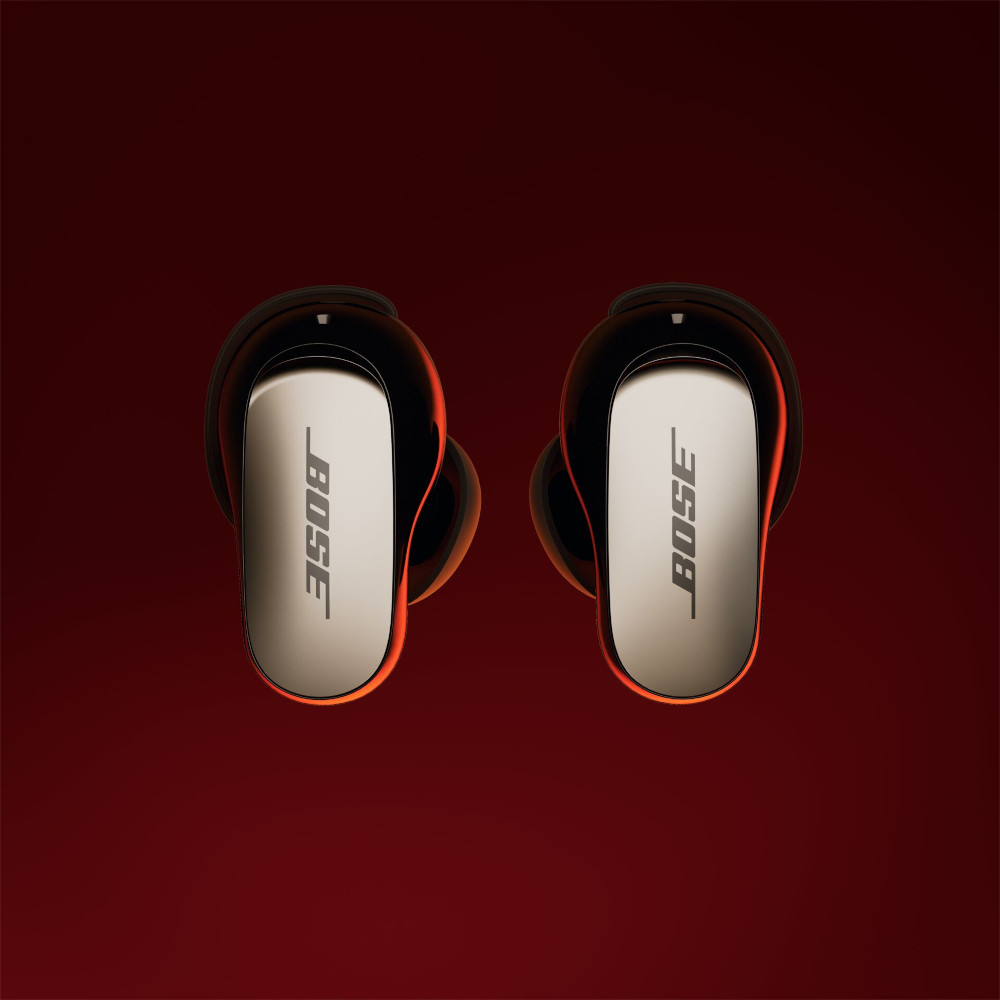 Bose earbuds on red background. The earbuds are black and silver with the Bose logo.