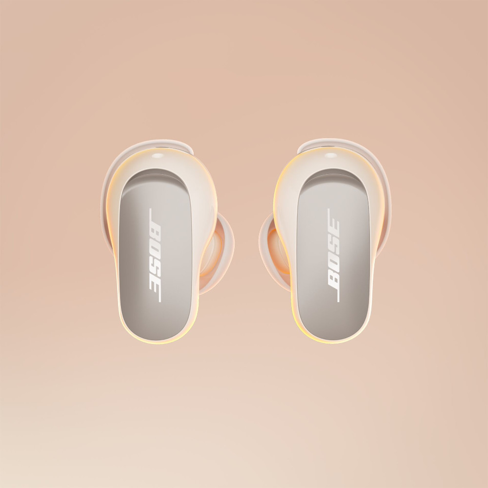 Twee witte Bose-oordopjes met het Bose-logo, op een lichtoranje achtergrond.