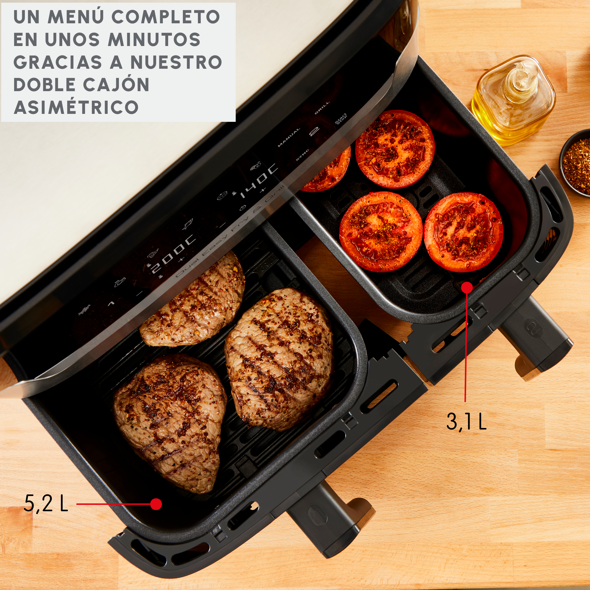 Freidora de aire con comida, mostrando dos compartimentos con carne cocida y tomates.