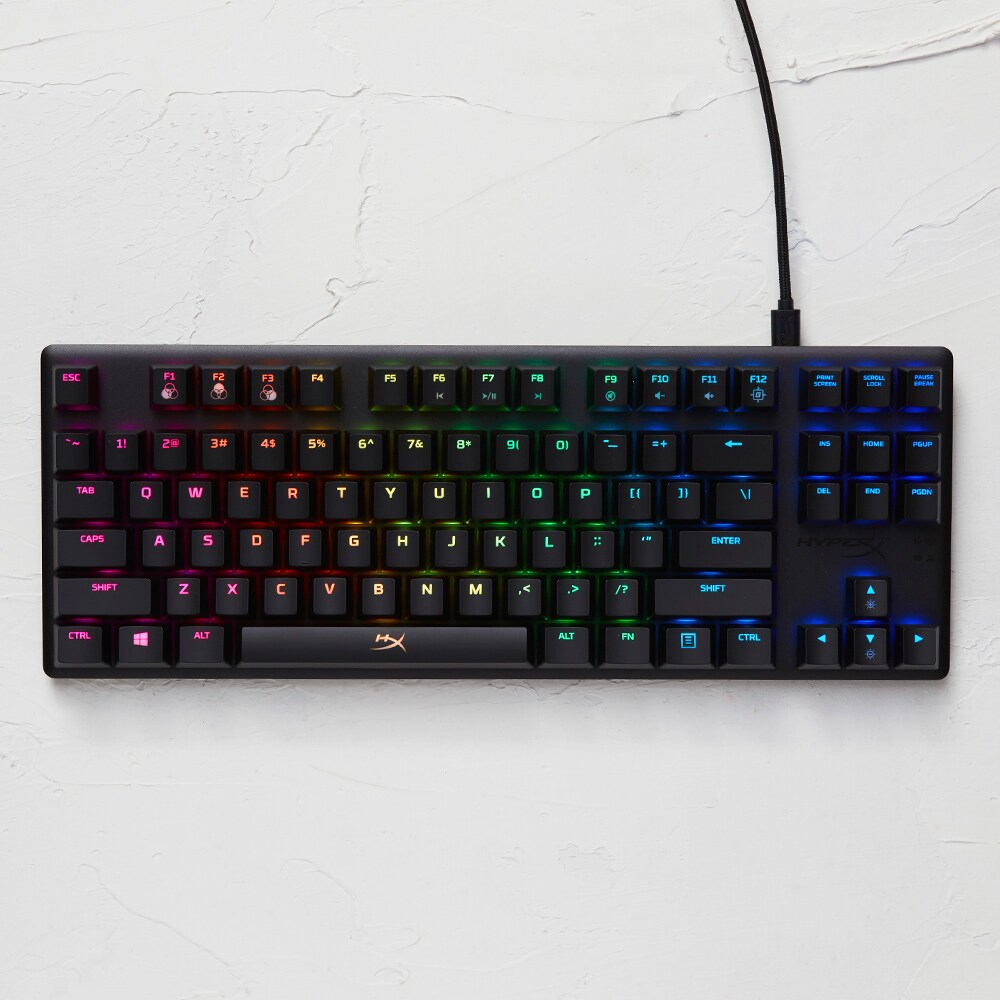 Schwarze Tastatur mit bunten Tasten auf heller Oberfläche.