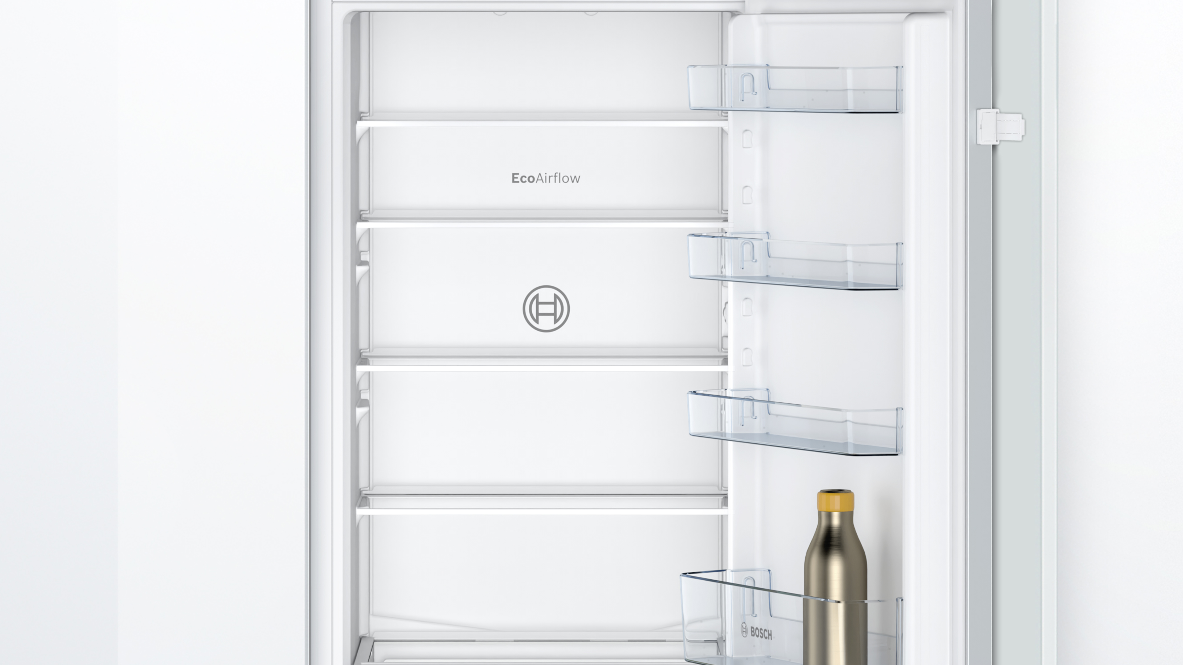 Innenseite eines weißen Kühlschranks mit Regalen und einer Flasche.