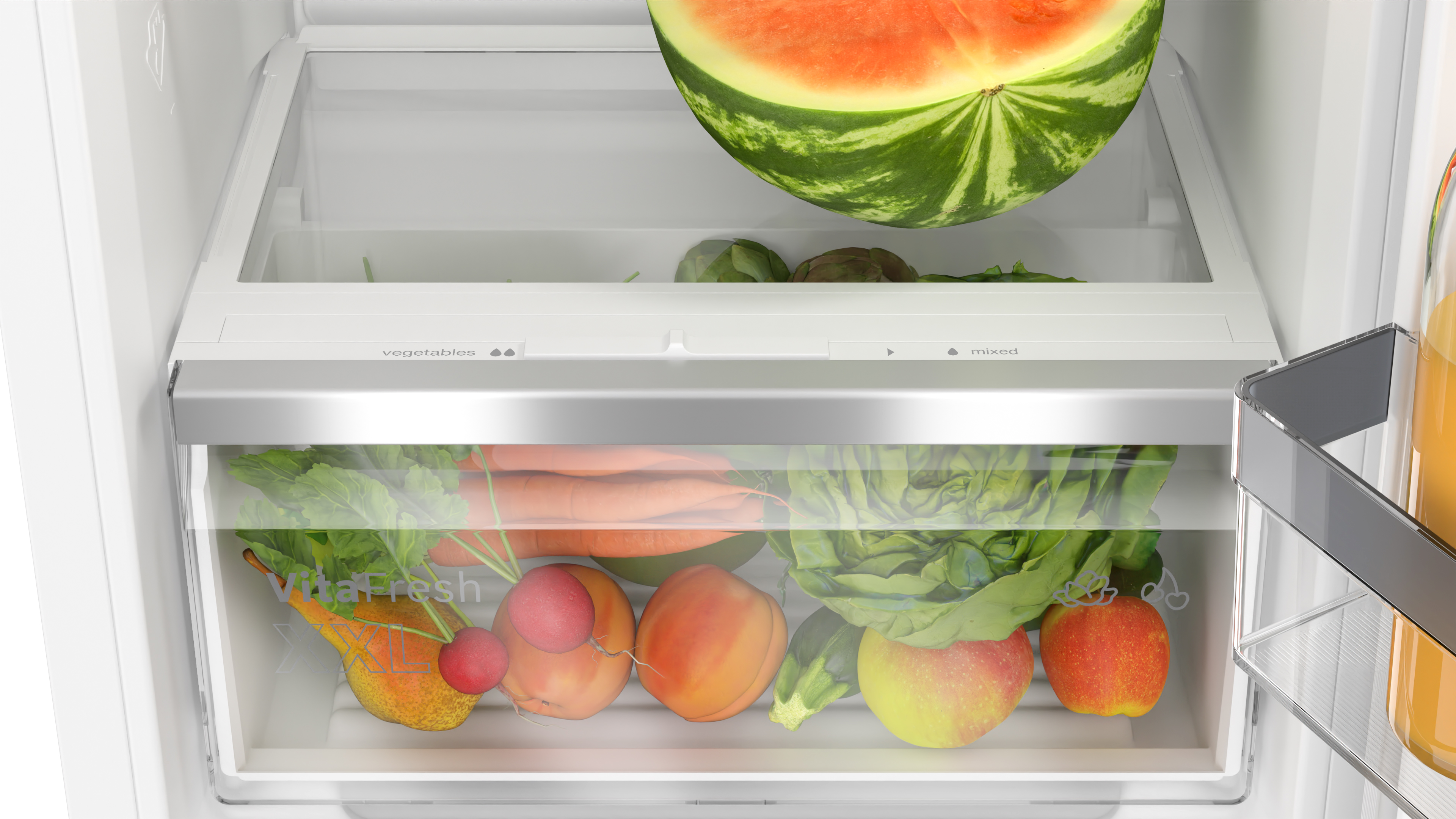 Eine Kühlschublade ist voller Gemüse und Obst, einschließlich Wassermelone.