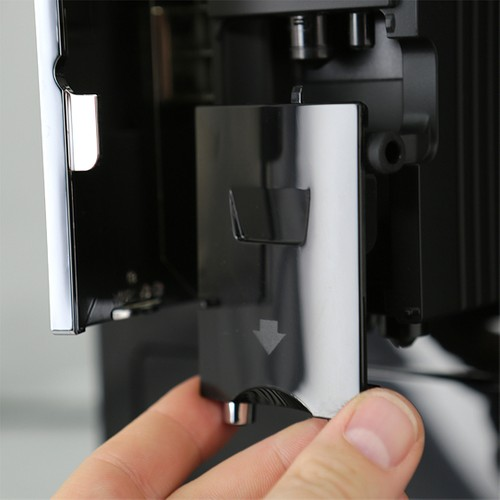 Bir el, bir makinede siyah bir bölmeyi açıyor.