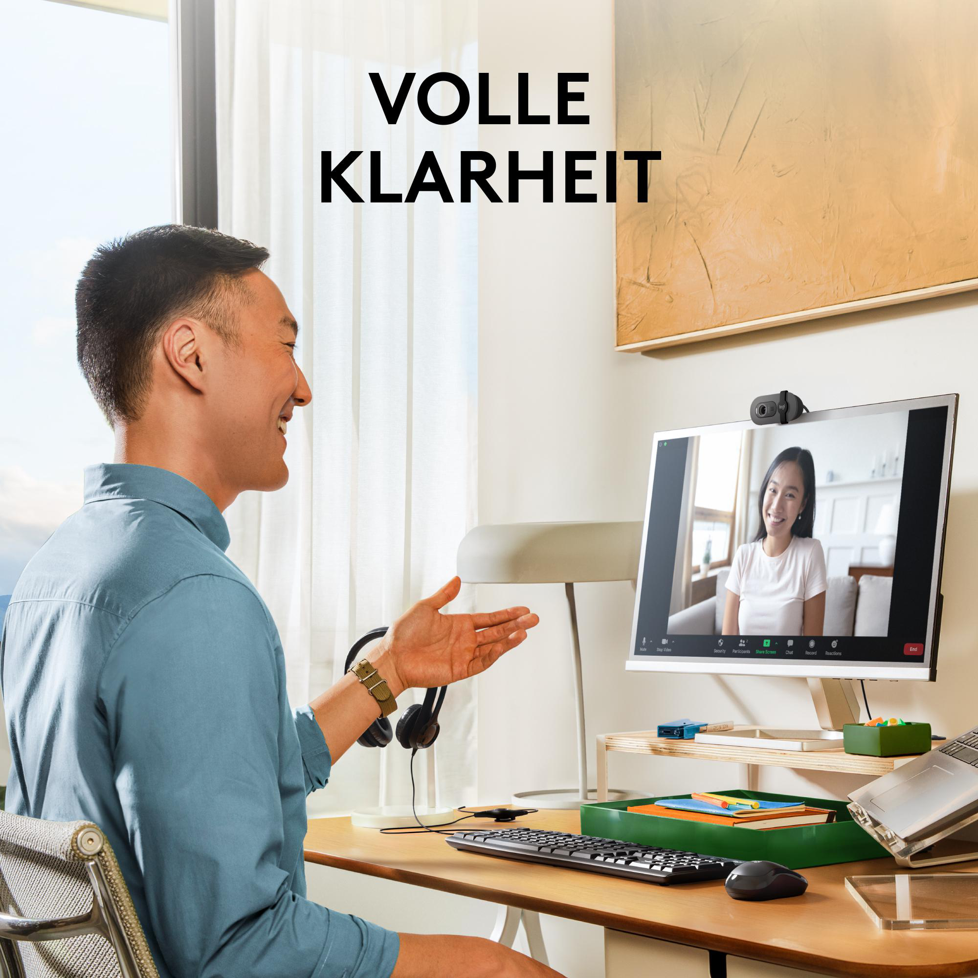 Mann im Videoanruf. Der Bildschirm zeigt eine Frau, und der Mann scheint zu lächeln. Schreibtisch mit Objekten.