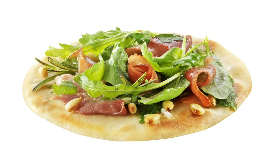 Pizza friss zöldségekkel, sonkával, fenyőmaggal és rozmaringgal fehér felületen.