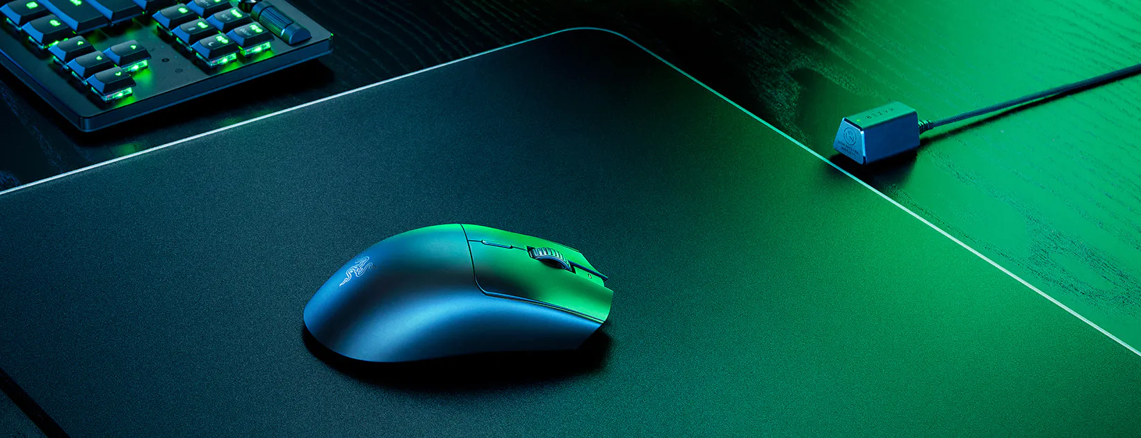Eine Razer Gaming-Maus auf einem schwarz-grünen Mauspad. Die Maus ist blau-grün, das Pad schwarz.