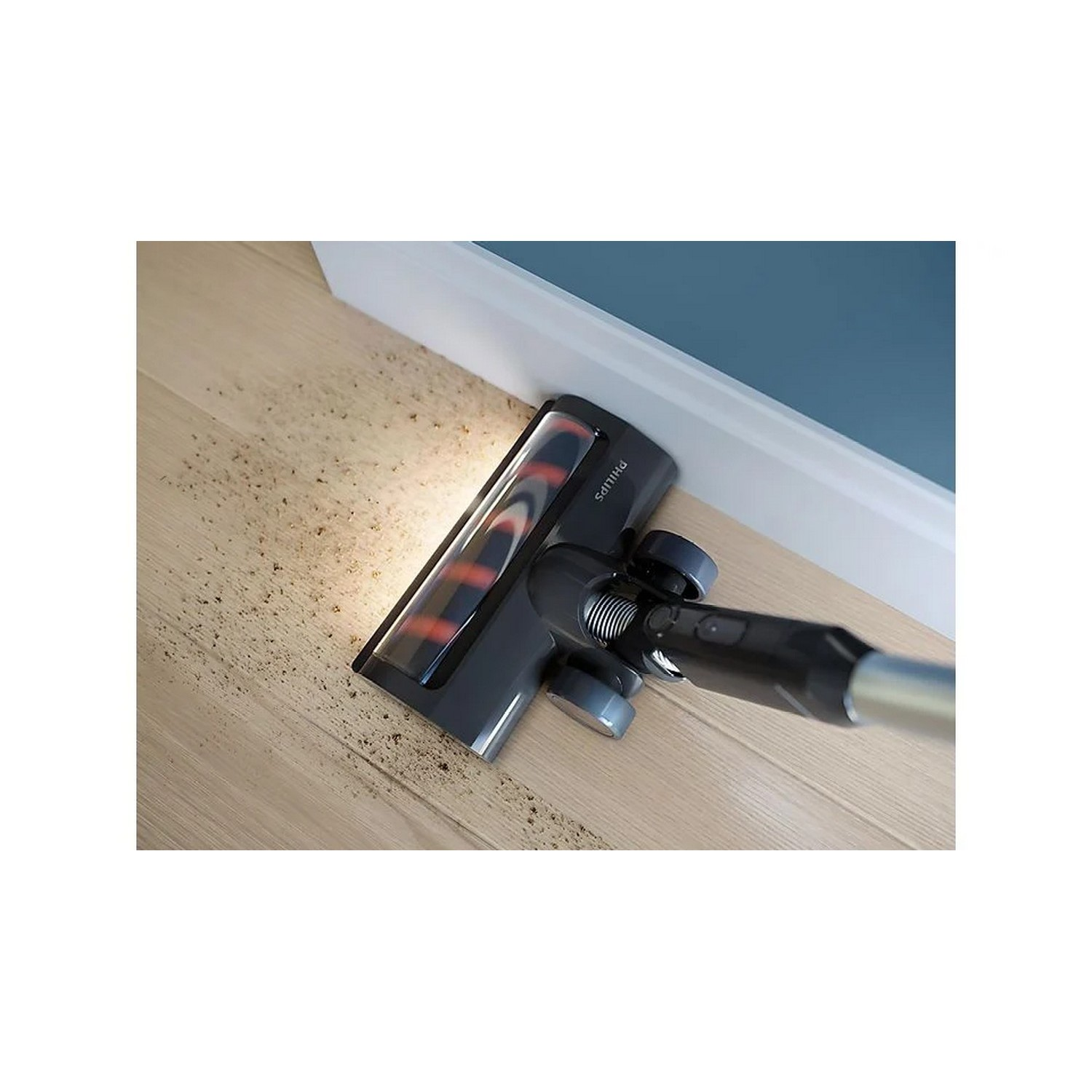 Een stofzuigerkop op een houten vloer, die stof opzuigt.