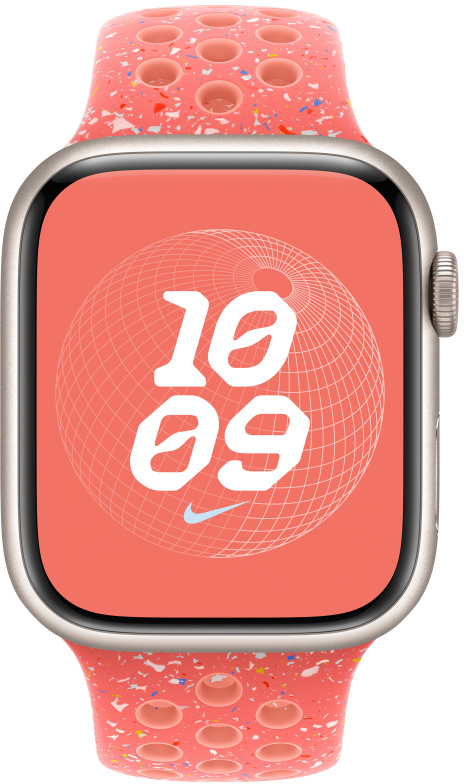 Apple Watch rózsaszín szíjjal, fehér pöttyökkel. Az óralap az időt és egy glóbusz-szerű mintát mutat.