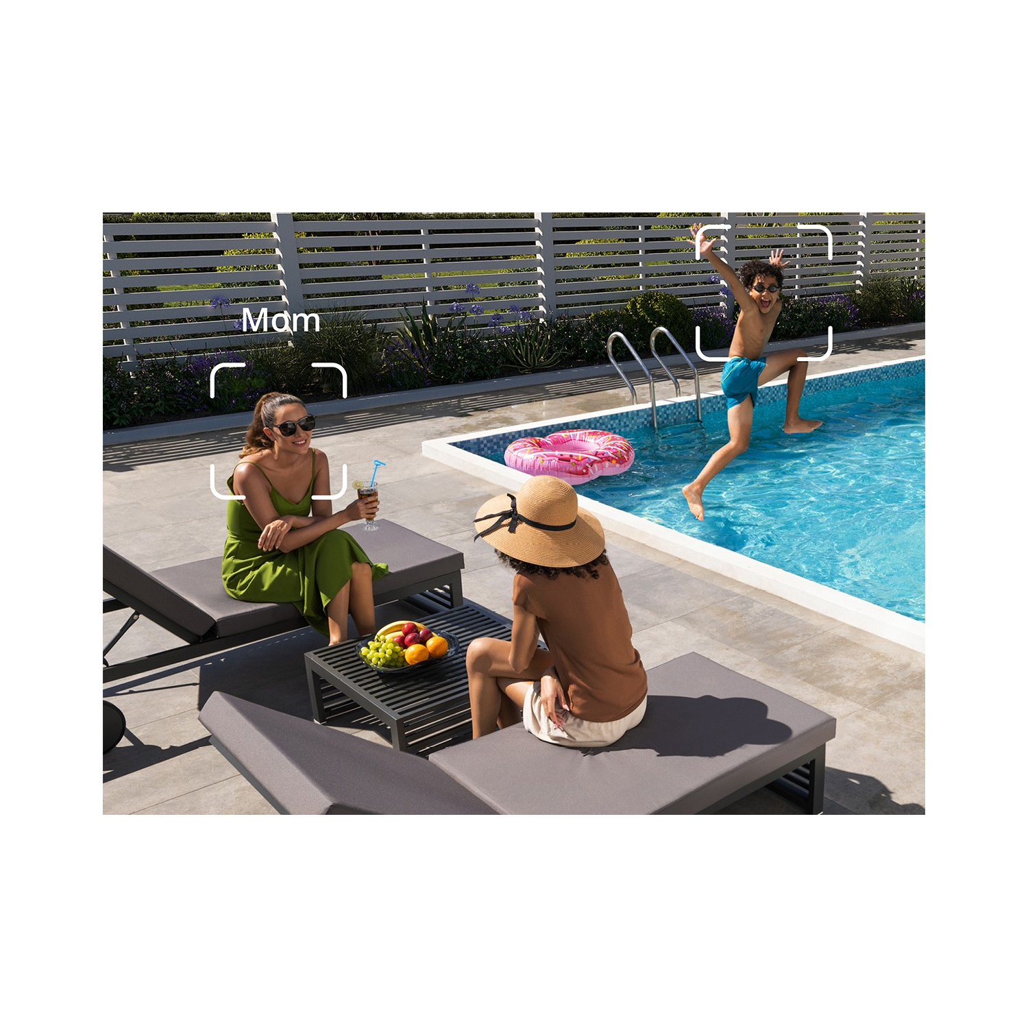 Scène au bord de la piscine : Femme et personne sur une chaise longue. Un enfant saute dans la piscine.