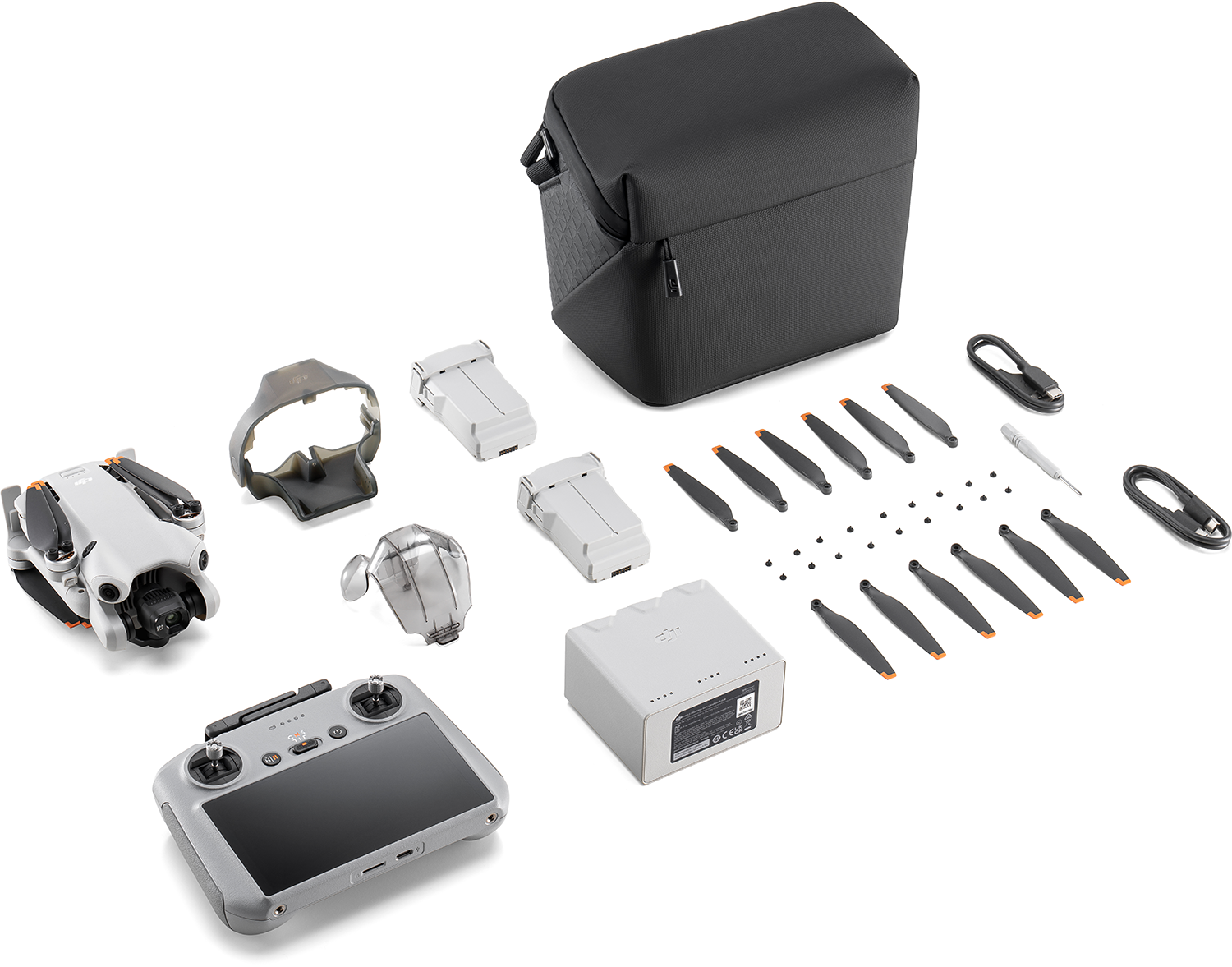 DJI Mini 3 Pro drón készlet. Drón, távirányító, akkumulátorok, légcsavarok és tok fehér felületen.
