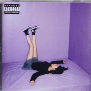 Ein Albumcover mit einer Person, die mit hochgestreckten Beinen auf einem Bett liegt. Der Hintergrund ist lila.