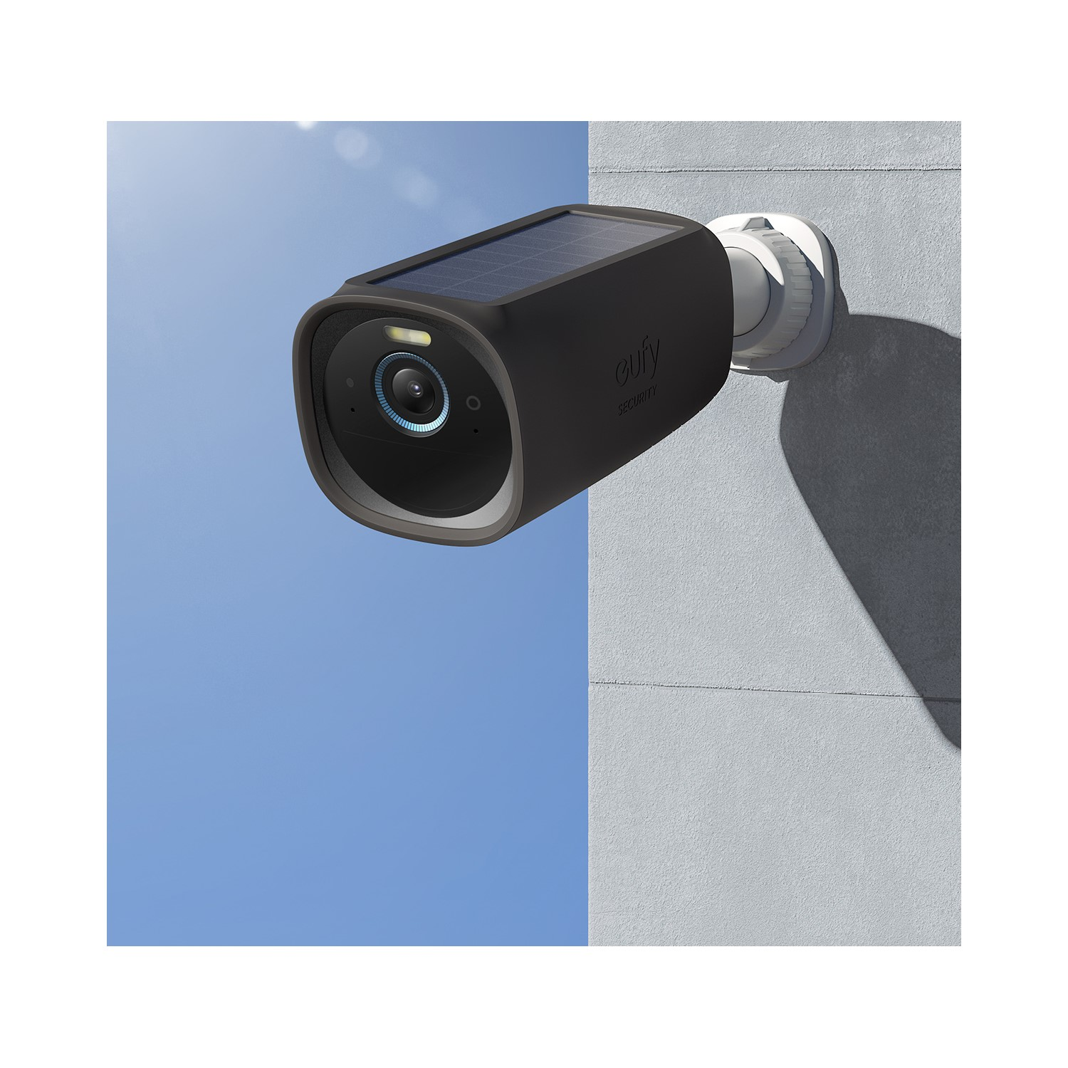 Une caméra de sécurité noire montée sur un mur blanc, avec un ciel bleu.