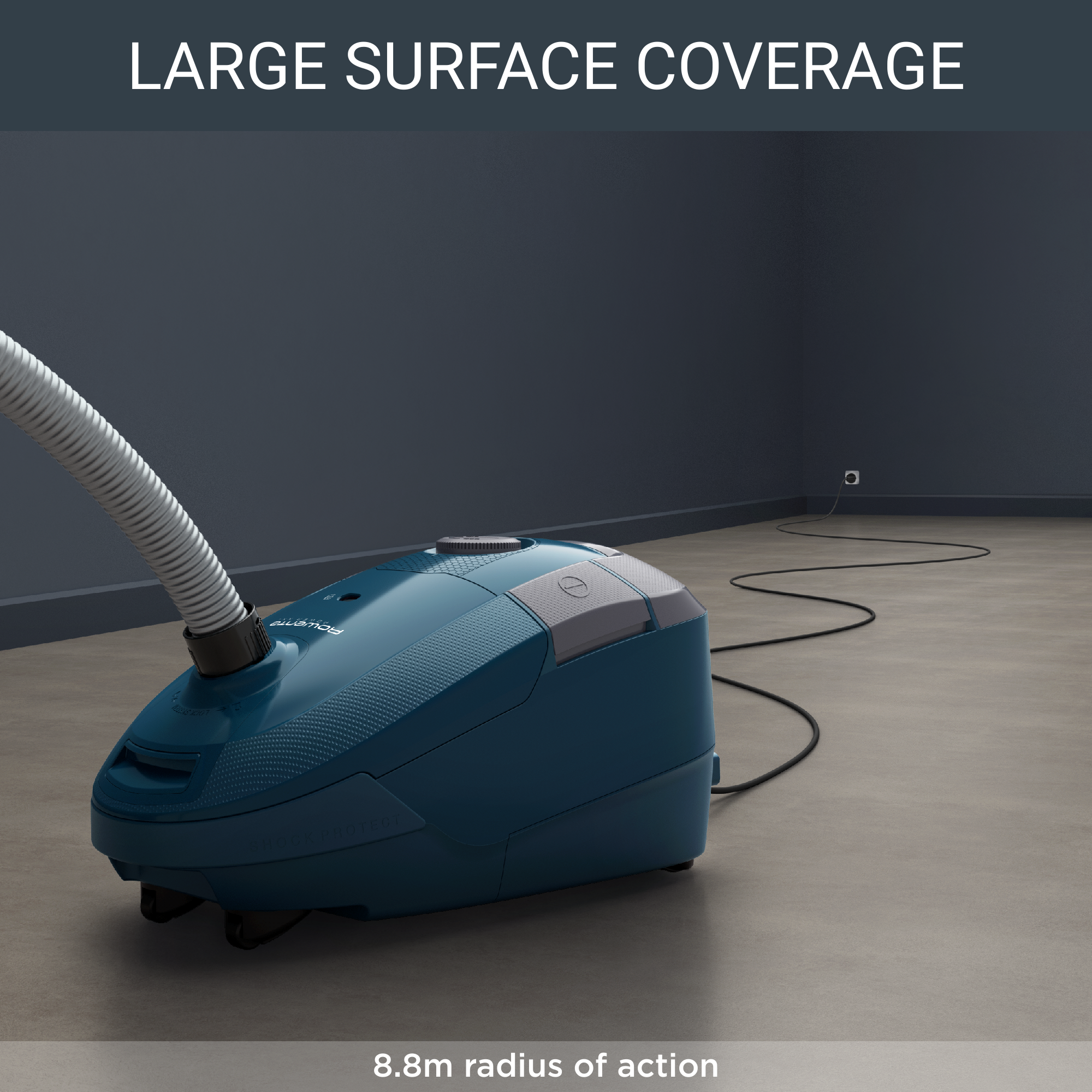 A blue vacuum cleaner on a wooden floor with a hose extending to a wall. Text reads, "Large surface coverage."
