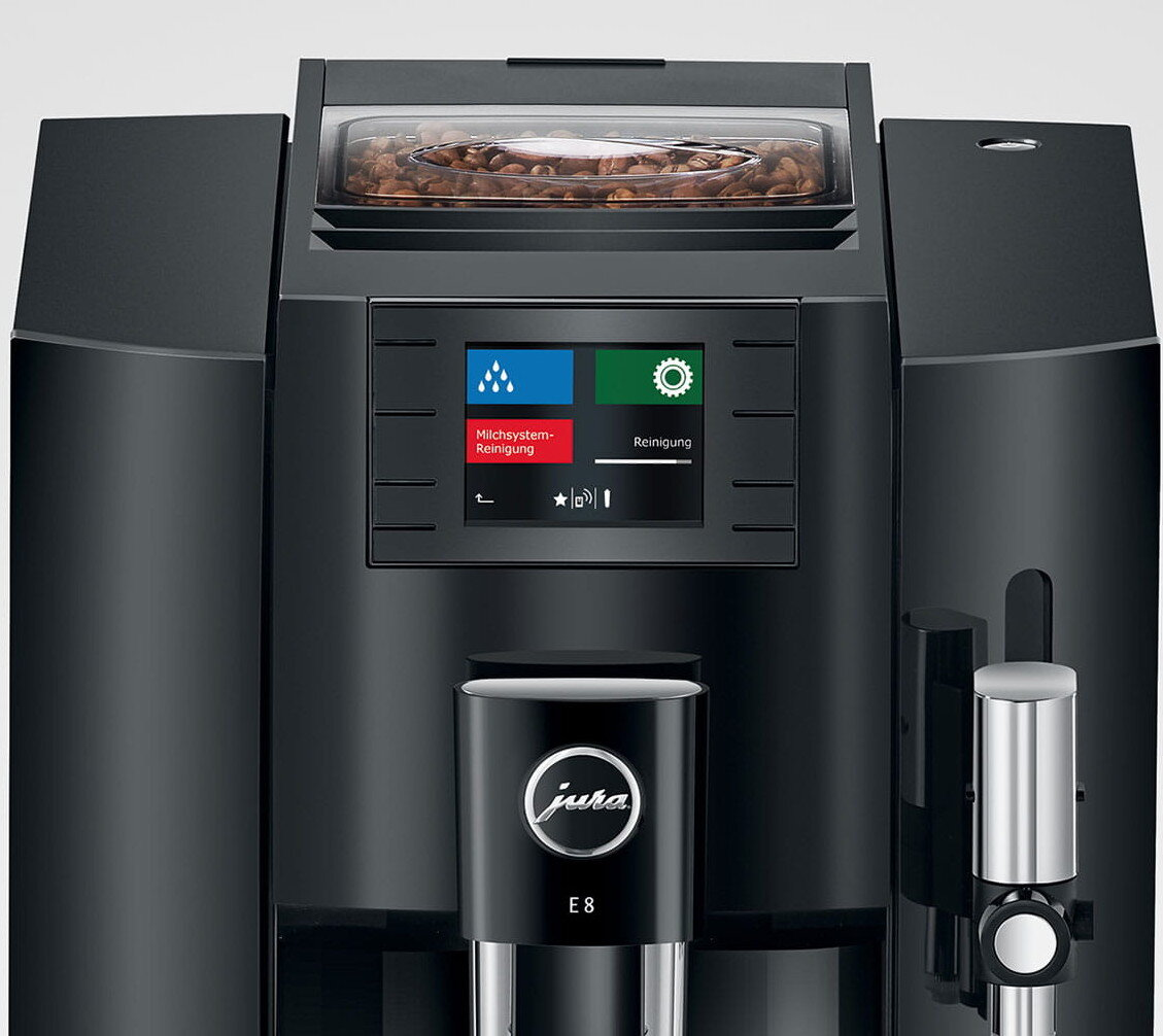 Zbliżenie czarnego ekspresu do kawy Jura. Ma pojemnik na ziarna i ekran dotykowy.