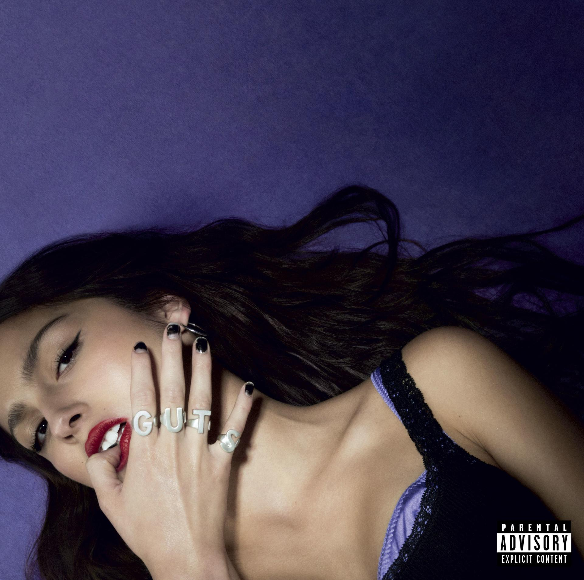 Olivia Rodrigo album borítója. A 'GUT' betűket érinti az ujjain.