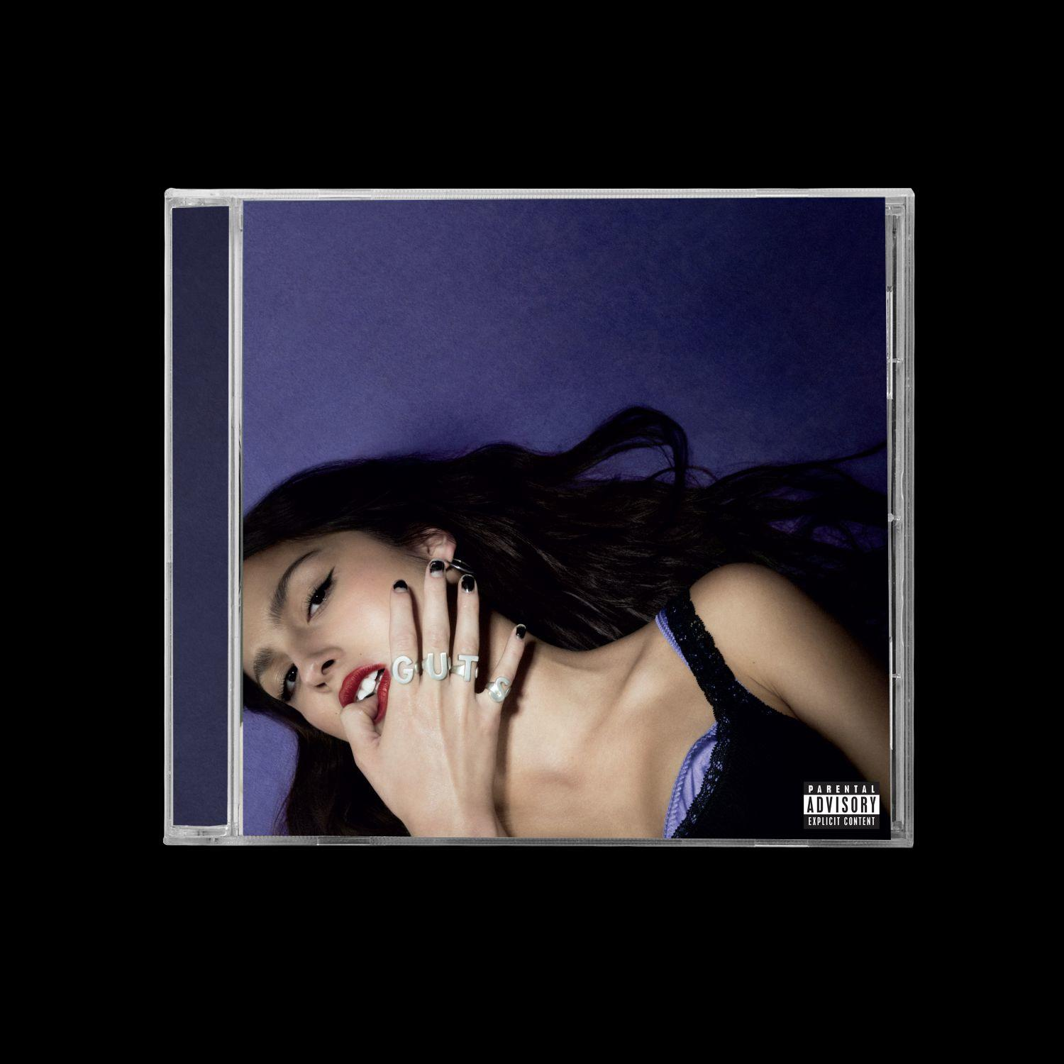 Olivia Rodrigo auf einem CD-Cover. Sie trägt einen Ring, der GUT buchstabiert, mit rotem Lippenstift.