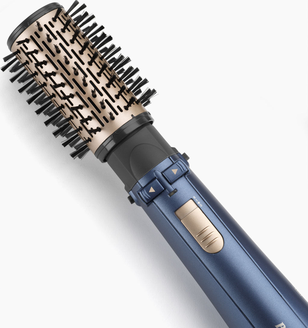 Una spazzola per capelli blu e oro su sfondo bianco, vista angolata.