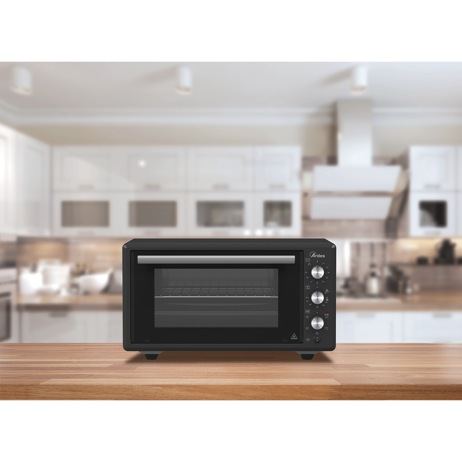 Forno da banco nero su superficie in legno. Lo sfondo mostra una cucina bianca e luminosa.