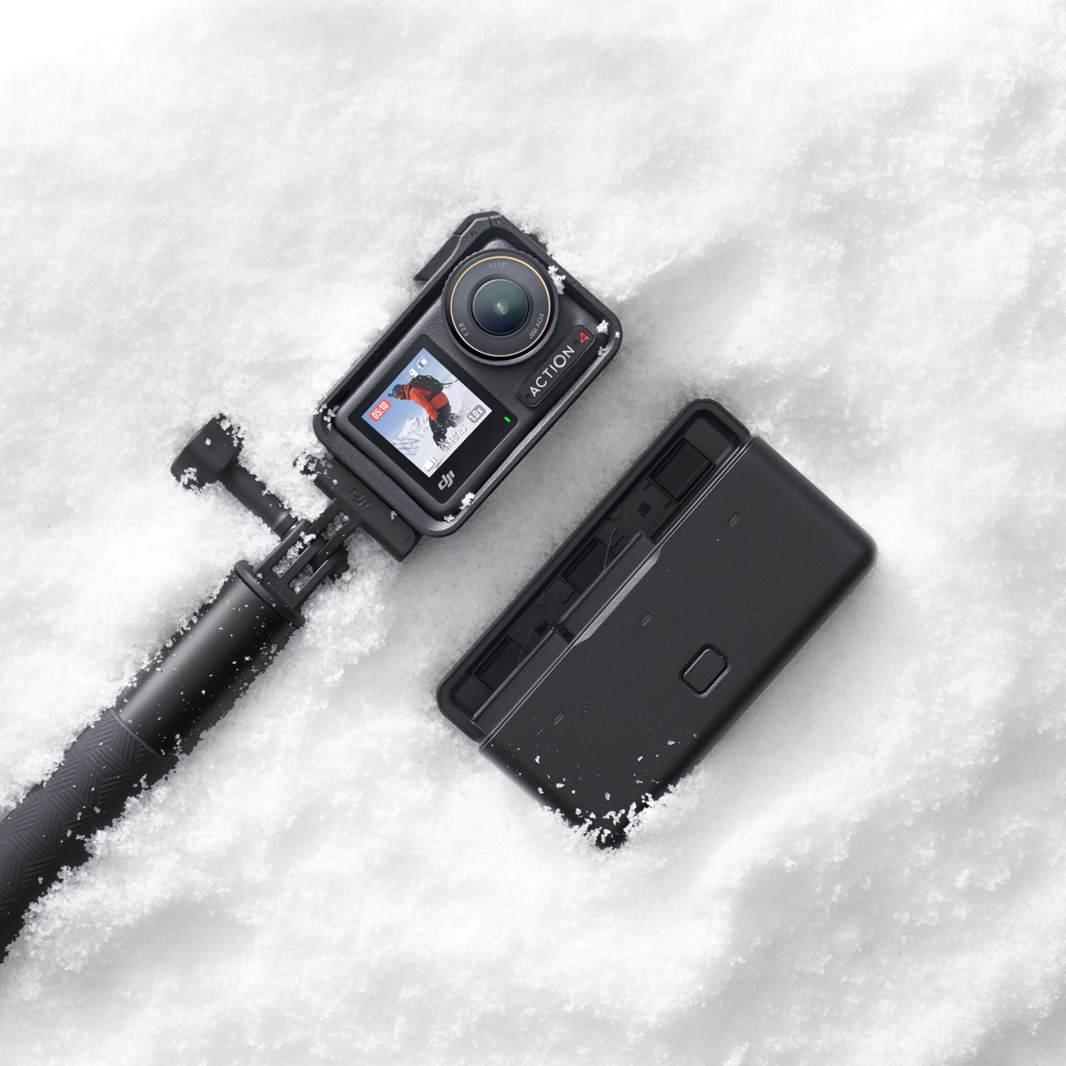 Una action camera nera con uno schermo che mostra una persona che scia sulla neve, con un'estensione nera.