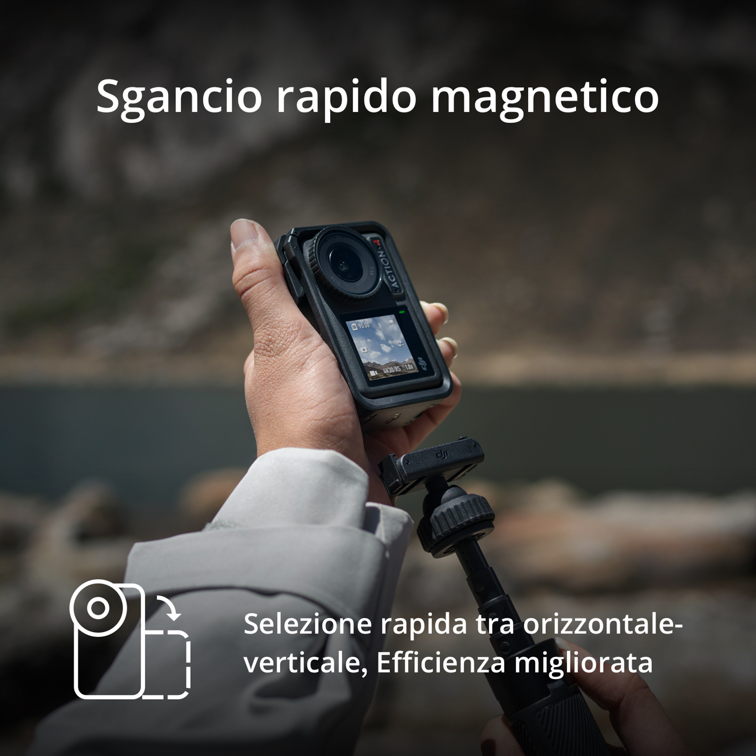 Una persona che tiene in mano una action camera nera, con un supporto a sgancio rapido e uno schermo che mostra un video.