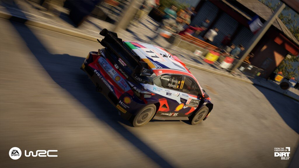Samochód wyścigowy w ruchu na torze, z logo EA Sports WRC w lewym dolnym rogu.