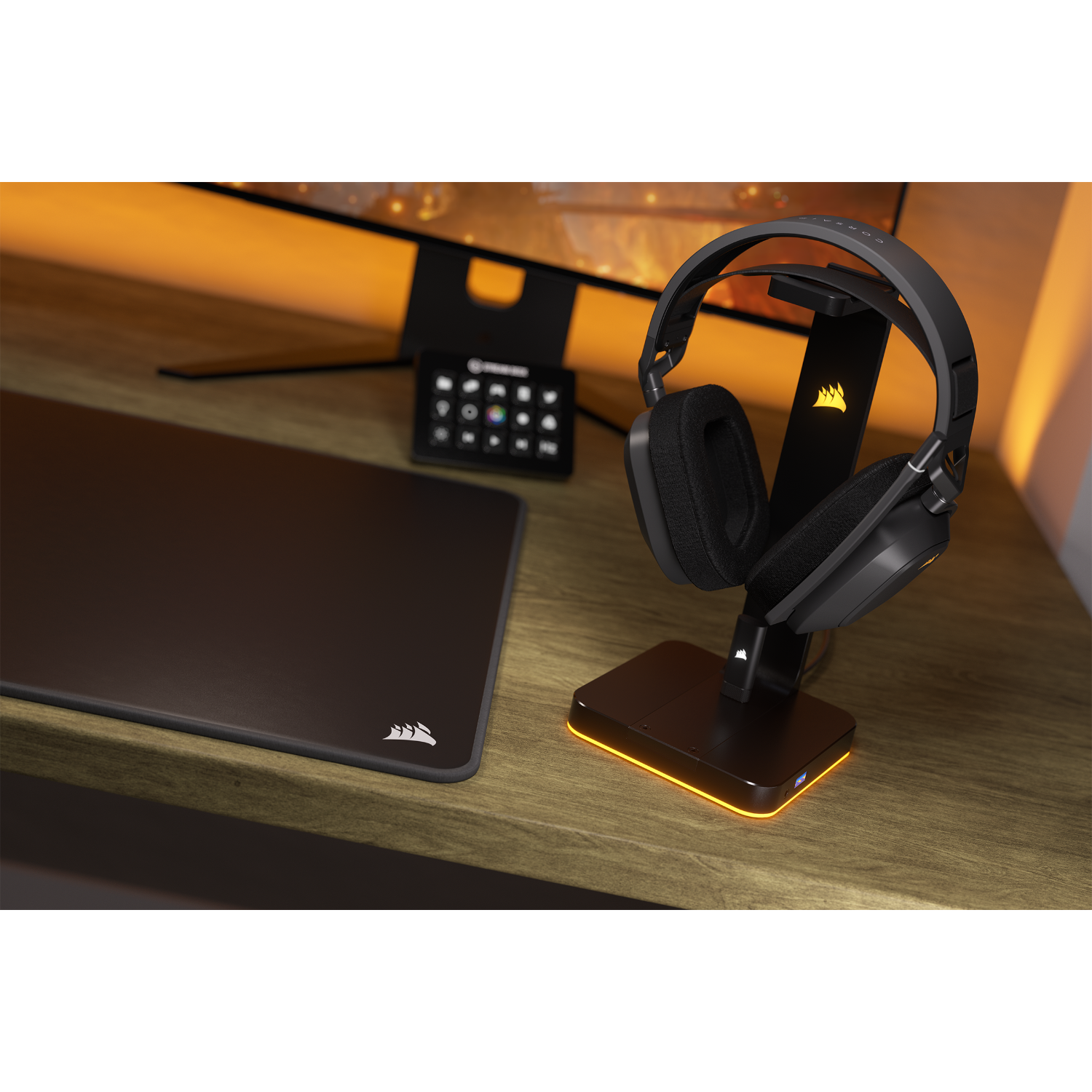 Gaming setup: headset on a stand, mouse pad, and monitor. The scene has warm lighting.