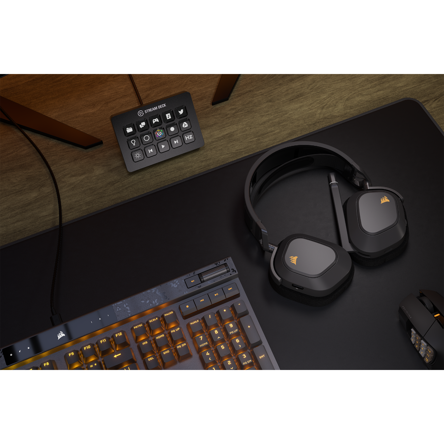 Gaming setup: keyboard, headset, mouse, and a stream deck, all on a wooden desk.