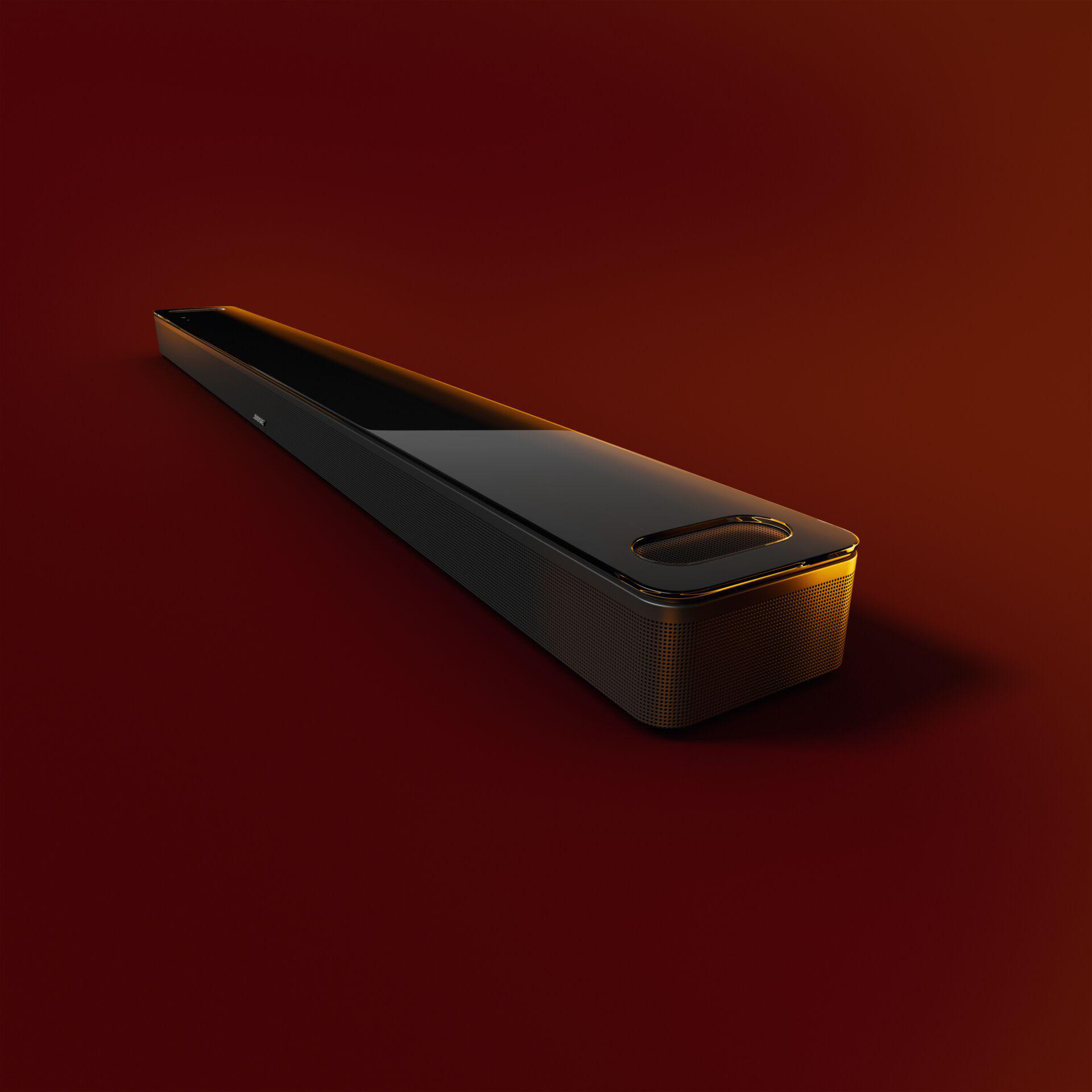 Eine schwarze Soundbar auf rotem Hintergrund.