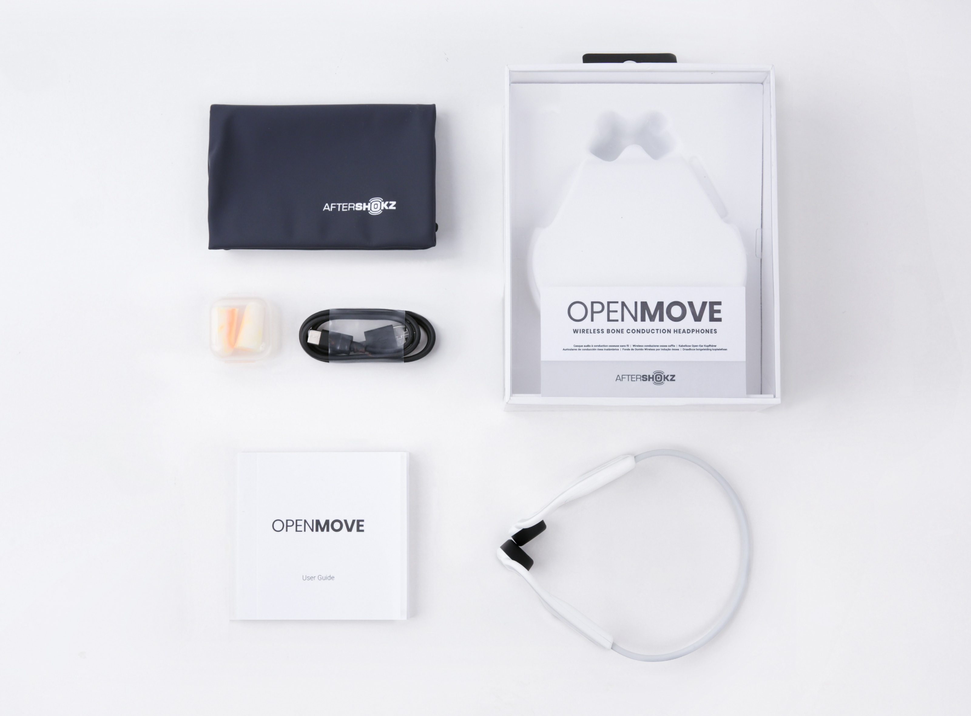 Kicsomagolt Aftershokz OpenMove fejhallgató és tartozékai, beleértve egy tokot, töltőt és használati útmutatót.