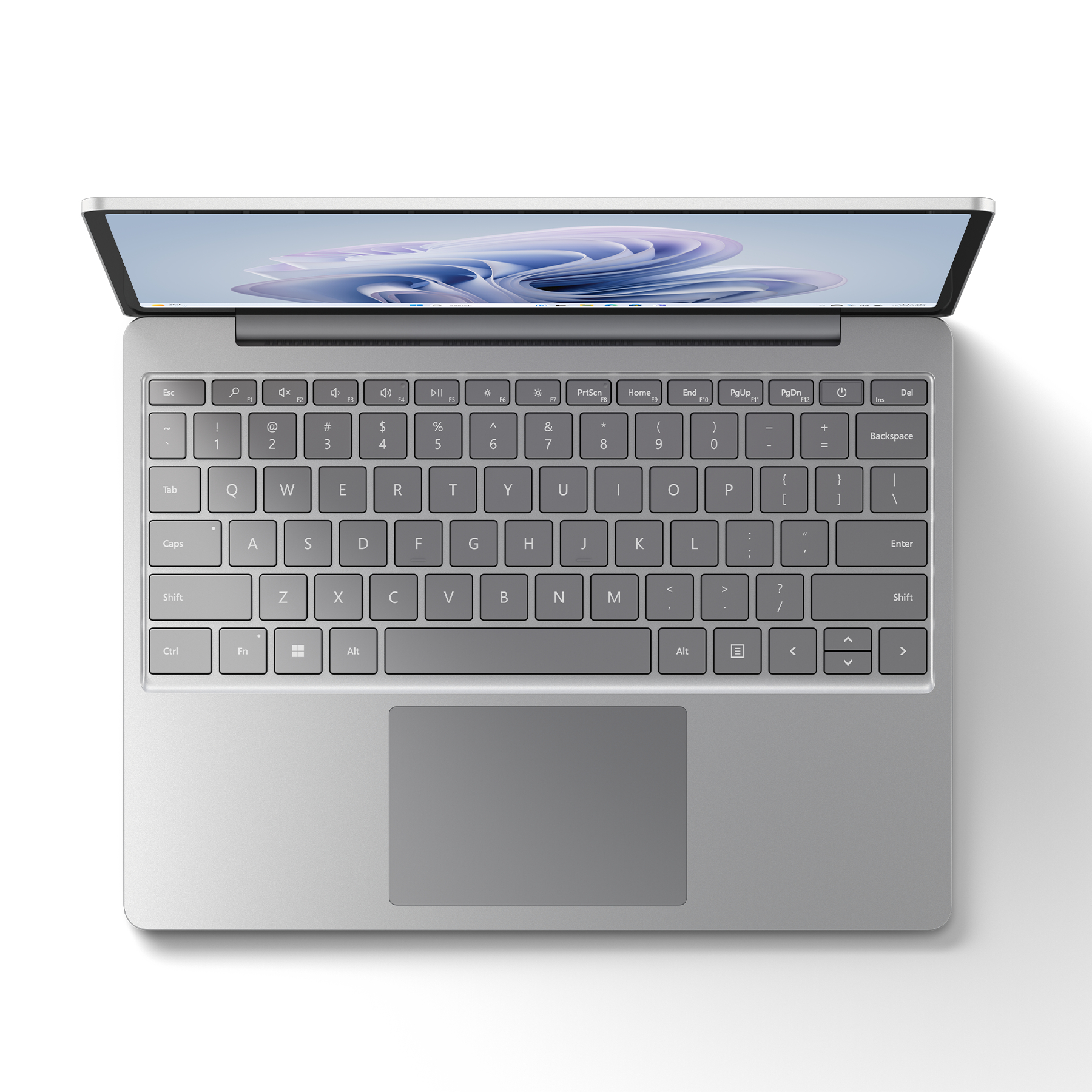 Draufsicht auf einen silbernen Laptop mit Tastatur, Bildschirm offen. Weißer Hintergrund.