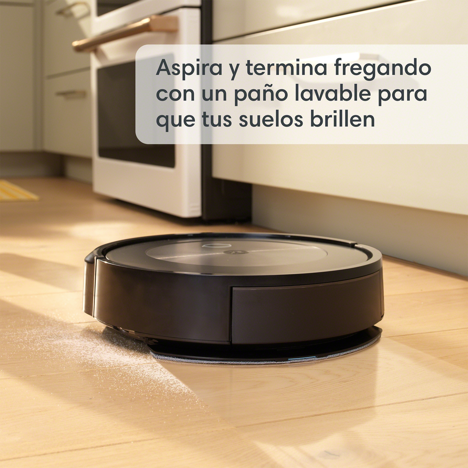 Una aspiradora robot negra en un suelo de madera, con texto encima.