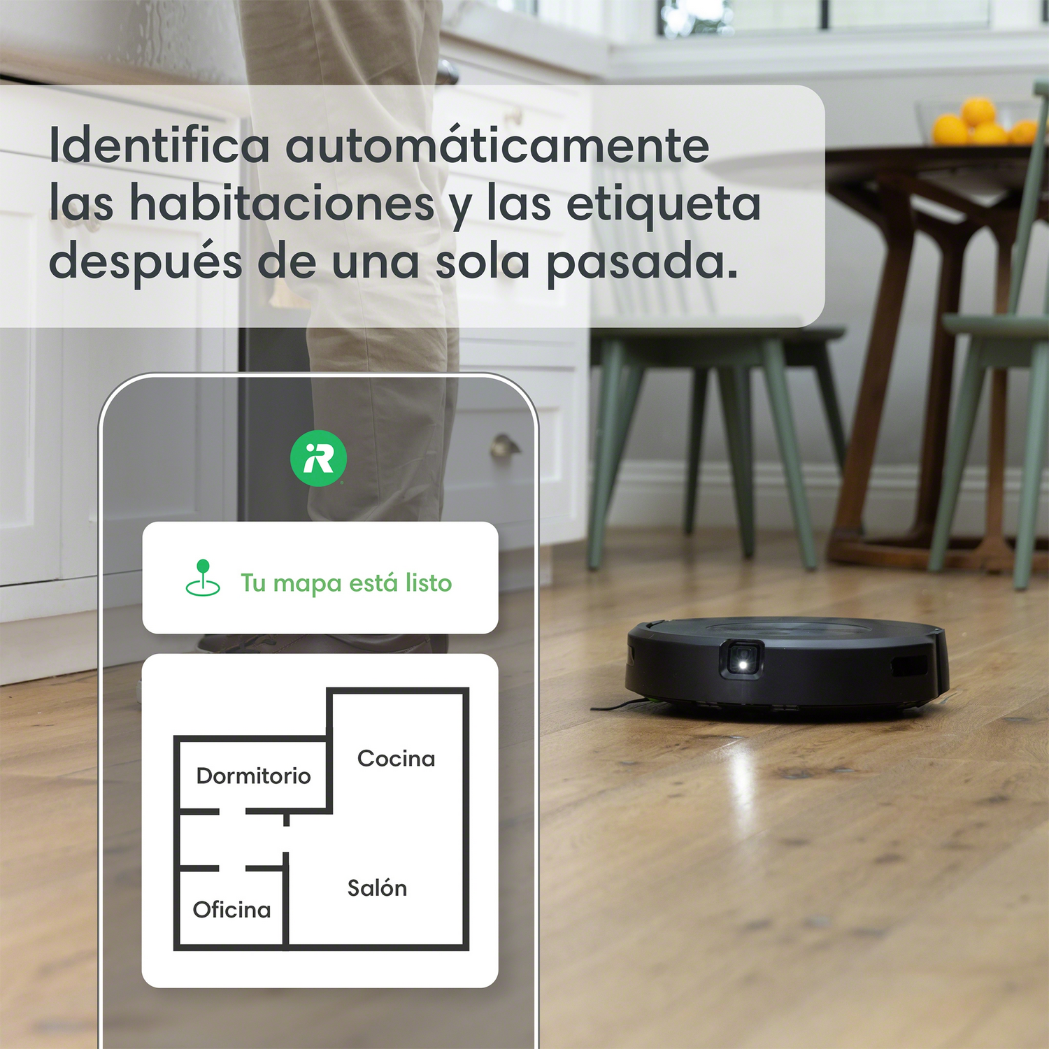 Aspiradora robot en piso de madera, con un teléfono que muestra un mapa y etiquetas de habitaciones.
