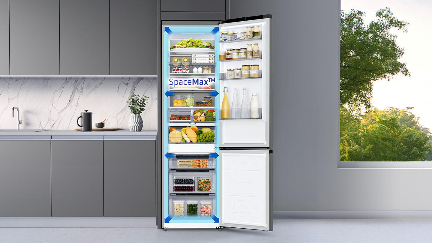 Offener Kühlschrank voller Lebensmittel. Gemüse, Obst und Getränke sind darin. Graue Küche.