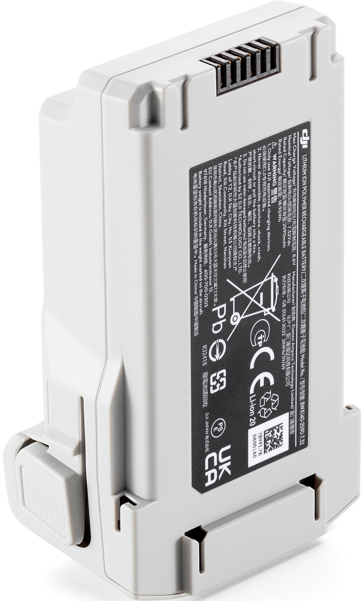 Une batterie de drone grise avec des avertissements et des spécifications imprimés. Elle a un port de charge.