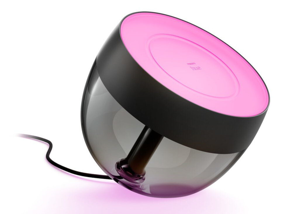 Lampa Philips Hue. Czarna podstawa, skośna konstrukcja i różowo podświetlony wierzch, z czarnym przewodem zasilającym.