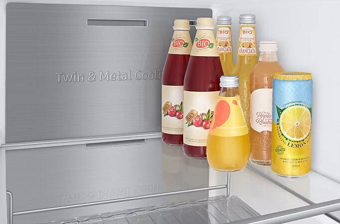 Wnętrze lodówki: butelki z sokiem, butelki z wodą i puszka lemoniady.