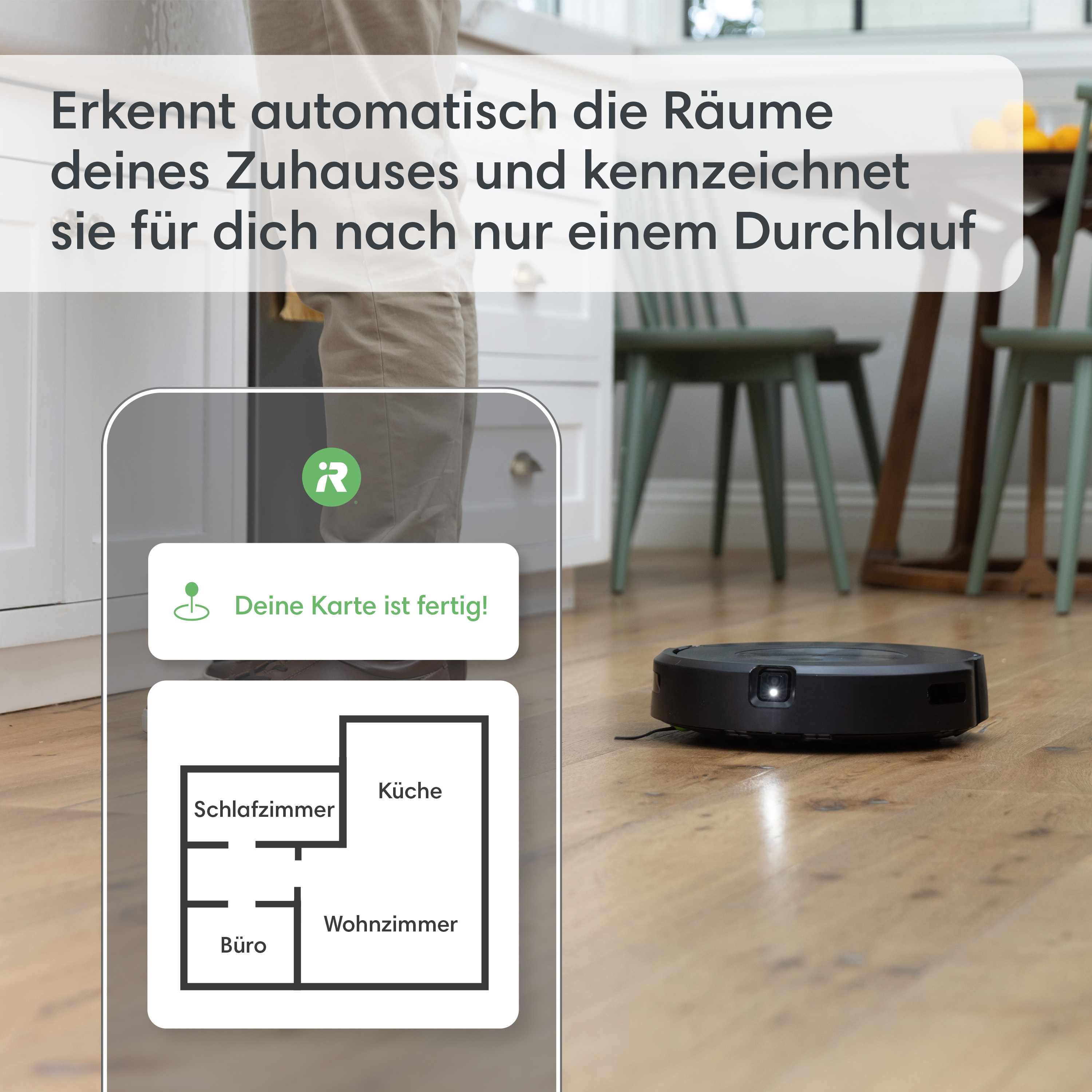 Ein Telefonbildschirm mit einem Hausplan und ein Roboter-Staubsauger auf dem Holzboden.