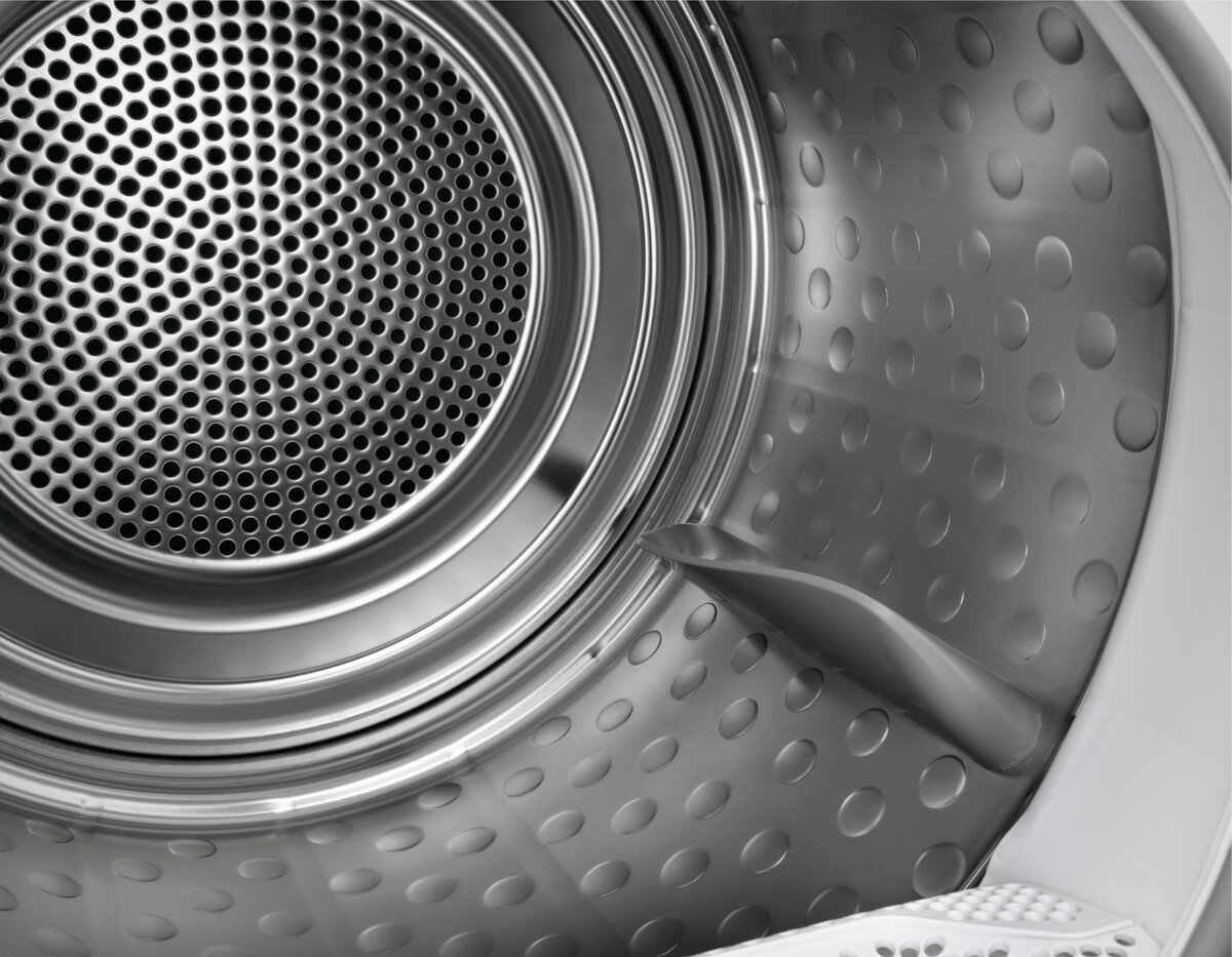 Wnętrze suszarki. Widoczny perforowany metal i inne elementy.